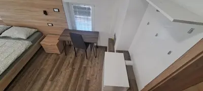 a small room with a bed and a desk and a table at Apartments Valdi in Tolmin