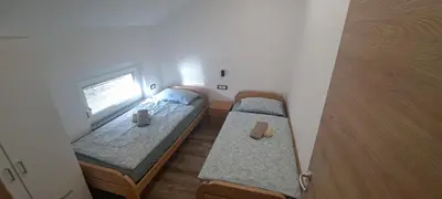 a small room with two beds and a window at Apartments Valdi in Tolmin