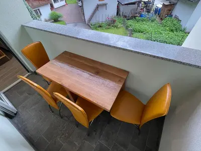 a table and some chairs and a table and a window at Apartments Valdi in Tolmin