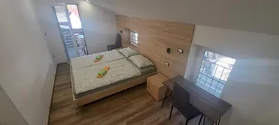 a small bedroom with a bed and a desk at Apartments Valdi in Tolmin