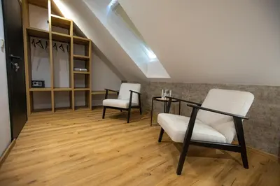 an attic room with two chairs and a table at Hiša TRELC- sobe in Komenda
