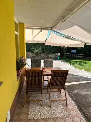 a patio with a table and two chairs and an umbrella at Apartment HOME SWEET HOME in Zgornje Škofije