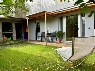 a chair sitting in the grass in front of a house at Apartma ART in Kobarid
