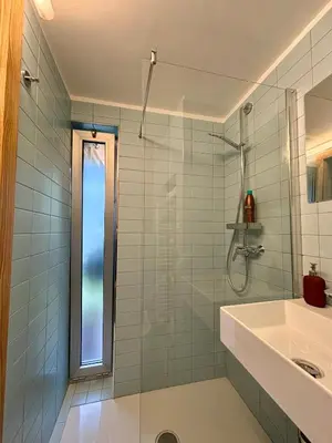 a bathroom with a glass shower and a sink at Apartma ART in Kobarid