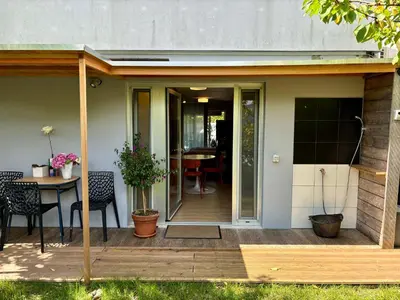 a patio with a table and chairs on a deck at Apartma ART in Kobarid