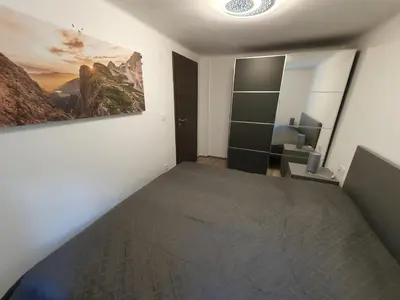 a bedroom with a bed and a painting on the wall at Apartment Ledince in Most na Soči