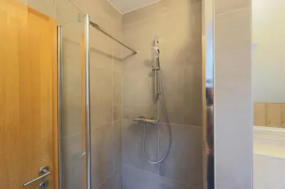 a shower with a glass door in a bathroom at Apartma Pehta in Kranjska Gora