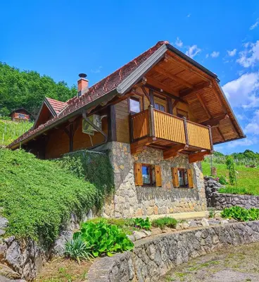 a stone house with a balcony on top of it at Vineyard cottage Kralj in Uršna Sela