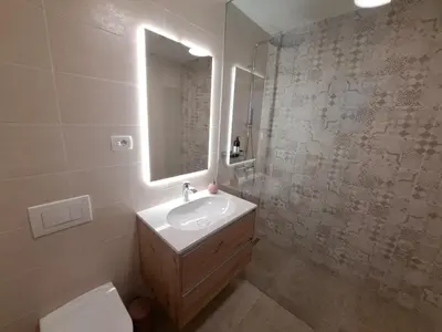a bathroom with a sink and a mirror and a toilet at S&B's RETREAT in Godovič