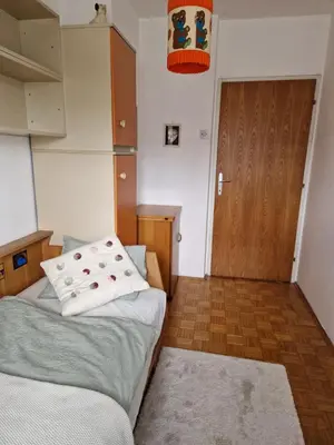 a small room with two beds and a wooden door at GreenFamilyAppartment near Ljubljana in Domžale