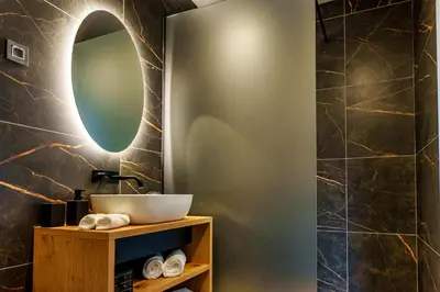 a bathroom with a sink and a mirror at Tourist Farm HOTEL FROST in Maribor