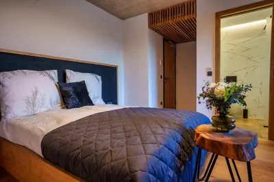 a bedroom with a bed and a table with a vase of flowers at Tourist Farm HOTEL FROST in Maribor