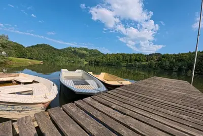 two boats are docked at a dock on a lake at Slivnisko Jezero Hisa in Veliki Rakitovec