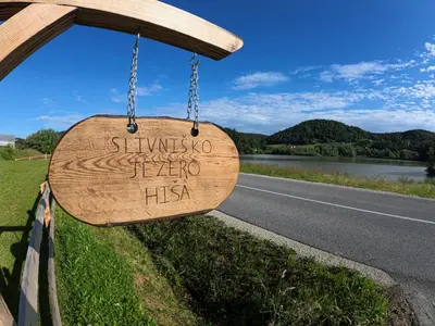 a wooden sign hanging on the side of a road at Slivnisko Jezero Hisa in Veliki Rakitovec