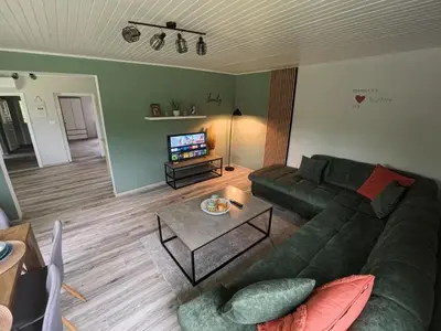a living room with a green couch and a table at Slivnisko Jezero Hisa in Veliki Rakitovec