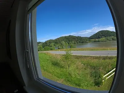 a window in a train looking out at a highway at Slivnisko Jezero Hisa in Veliki Rakitovec