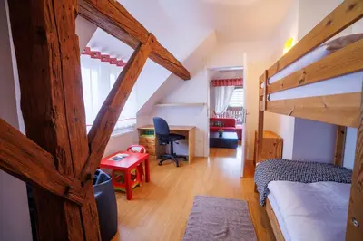 a bedroom with two bunk beds and a desk at Hiša na Dovjem in Mojstrana