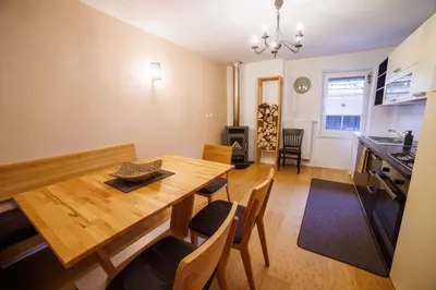 a kitchen and dining room with a wooden table and chairs at Hiša na Dovjem in Mojstrana