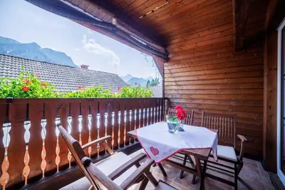 a table and two chairs on a balcony with a view at Hiša na Dovjem in Mojstrana