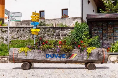 a wooden planter filled with flowers on a street at Hiša na Dovjem in Mojstrana