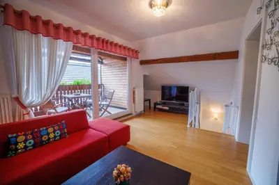 a living room with a red couch and a television at Hiša na Dovjem in Mojstrana