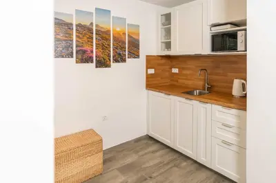 a kitchen with white cabinets and a sink at Studio Maria with Free Parking in Bohinj