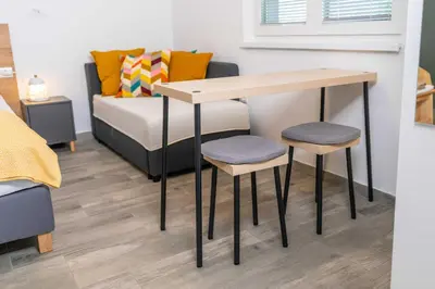 a table and two stools in a room with a bed at Studio Maria with Free Parking in Bohinj