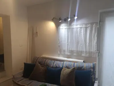 a couch in a living room with a window at apartma Lesnik Vila Ziba in Bohinj