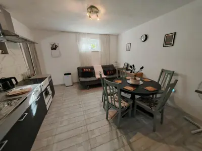a kitchen and living room with a table and a table and chairs at Apartma Oreh Vila Ziba in Bohinj