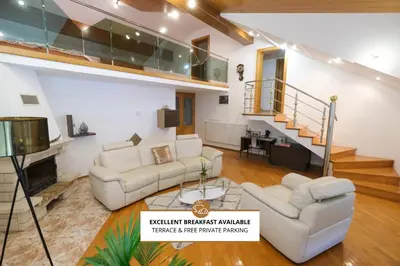 a living room with two couches and a staircase at Hiša Perla in Boštanj