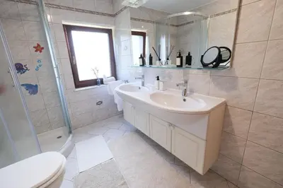 a bathroom with a sink and a shower and a toilet at Hiša Perla in Boštanj