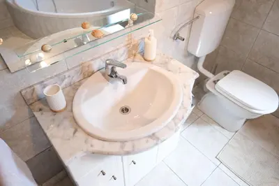 a bathroom with a sink and a toilet at Hiša Perla in Boštanj