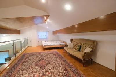 a living room with a couch and a bed at Hiša Perla in Boštanj