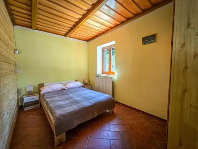 a bedroom with a bed in a room with a wooden ceiling at Apartma Maln in Kobarid