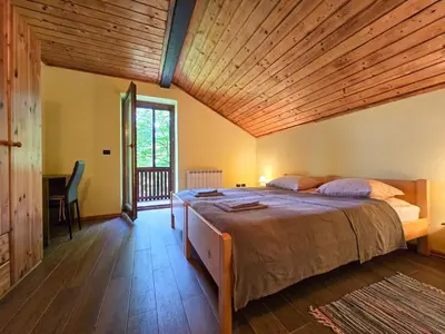 a bedroom with a large bed with a wooden ceiling at Apartma Maln in Kobarid