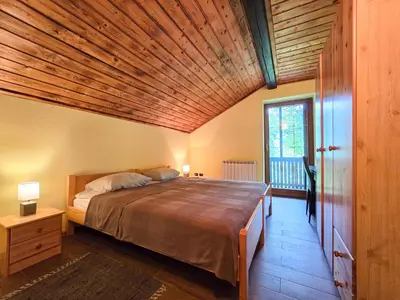 a bedroom with a large bed with a wooden ceiling at Apartma Maln in Kobarid