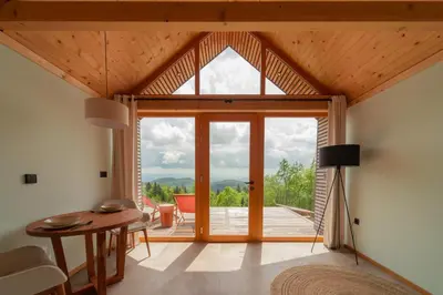 a living room with a table and a large window at Glamping Zarja, Vipava Valley in Zoll