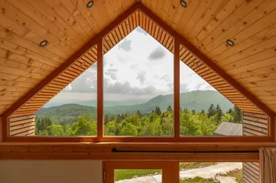 a window in a cabin with a view of the mountains at Glamping Zarja, Vipava Valley in Zoll