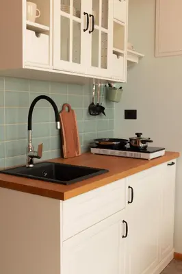 a kitchen with white cabinets and a sink at Glamping Zarja, Vipava Valley in Zoll