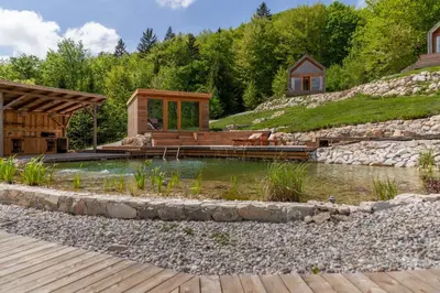 a backyard with a pond and a house at Glamping Zarja, Vipava Valley in Zoll