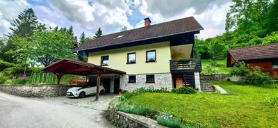 a house with a car parked in front of it at Aparthouse Bohinj in Bohinj