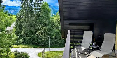 two chairs sitting on a porch with a fireplace at Aparthouse Bohinj in Bohinj