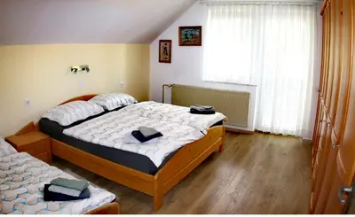 a bedroom with two beds and a large window at Aparthouse Bohinj in Bohinj