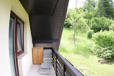 an outdoor balcony with two chairs and a window at Aparthouse Bohinj in Bohinj