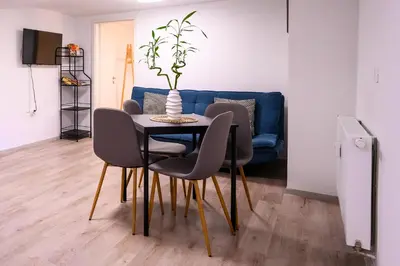 a dining room table with chairs and a blue couch at The Darling Loft in Ljubljana