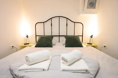 a large white bed with two towels on it at The Darling Loft in Ljubljana