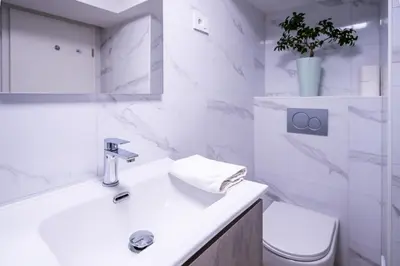 a white bathroom with a sink and a toilet at The Darling Loft in Ljubljana