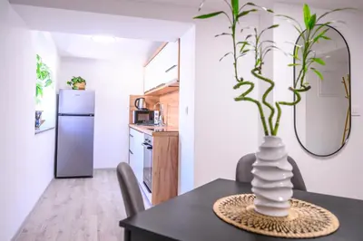 a dining room table with a vase with a plant in it at The Darling Loft in Ljubljana