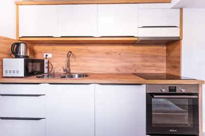 a kitchen with white cabinets and a sink at The Darling Loft in Ljubljana