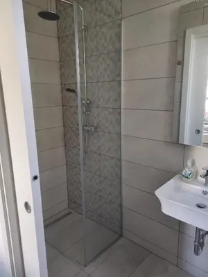 a shower with a glass door next to a sink at Apoteka in Lenart v Slovenskih Goricah